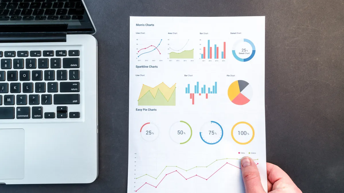Hand holding a printed performance report with charts