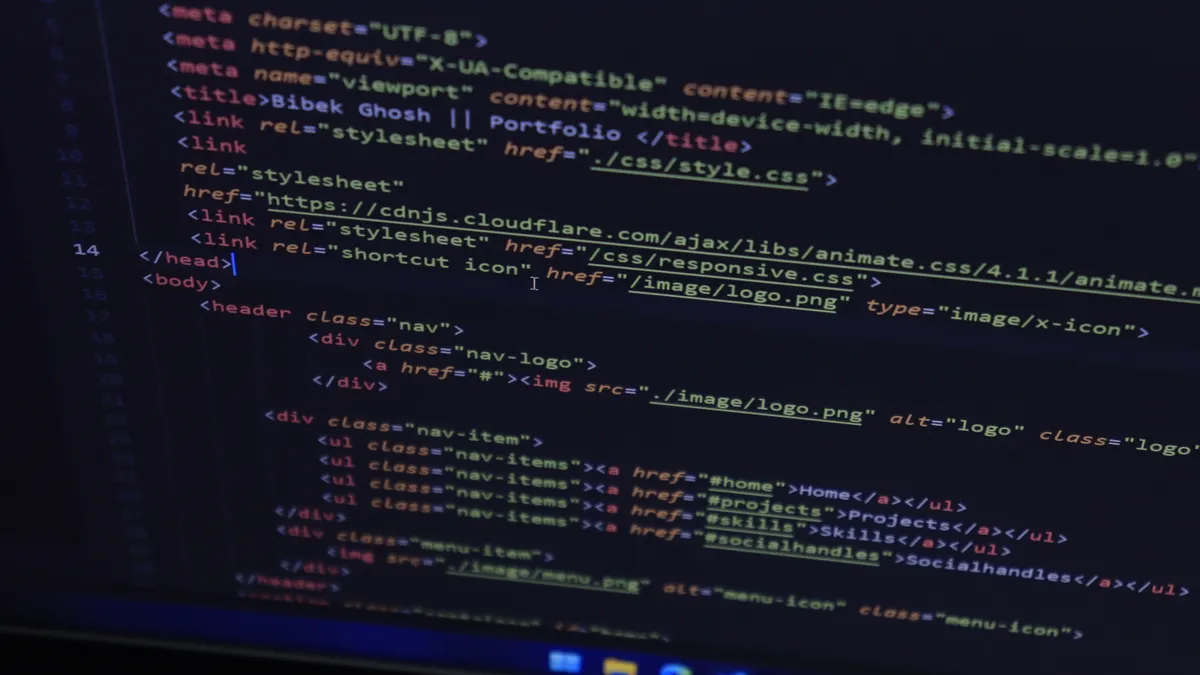 laptop displaying HTML code in a code editor
